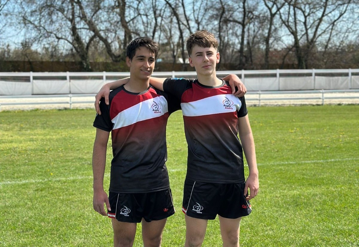 Zwei Nachwuchsspieler in Rugby-Austria-Trikots am Spielfeld